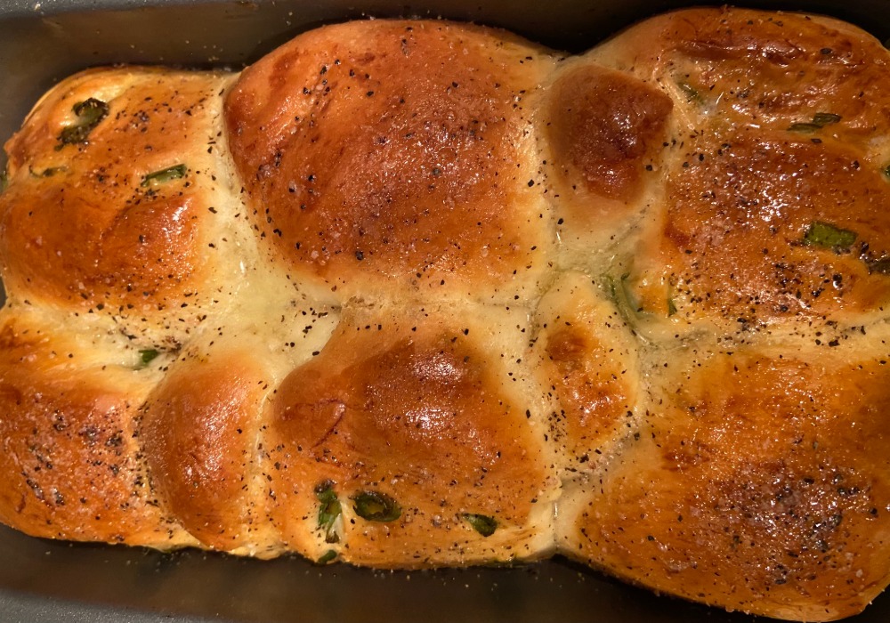 Milk bread rolls made with green onions in pan.
